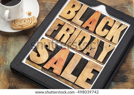 Black Friday sale - holiday shopping concept -word abstract in letterpress wood type on a digital tablet with a cup of coffee