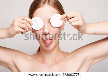 A picture of a happy woman cleaning her face with cotton pads over white background. Beautiful Face of Young Woman with Clean Fresh Skin close up. Youth and Skin Care Concept , mouth and tongue