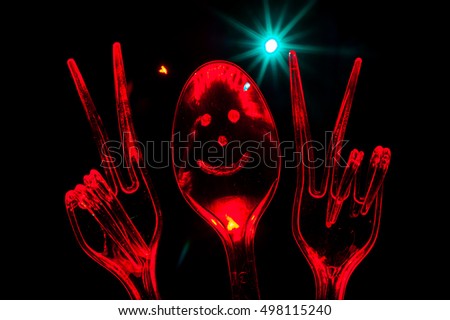 Victory sign represented using plastic forks and spoon - Abstract Light Painting at night - Light Art Photography