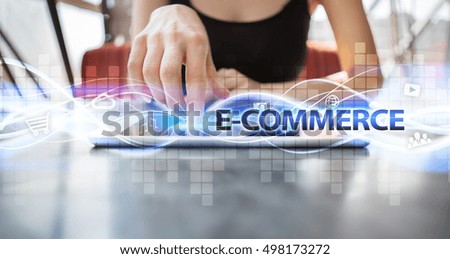 Woman is using tablet pc, pressing on virtual screen and selecting "E-commerce".