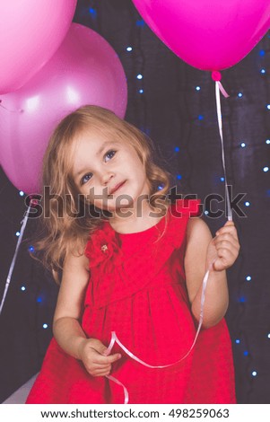 Little girl in studio with pink balloons