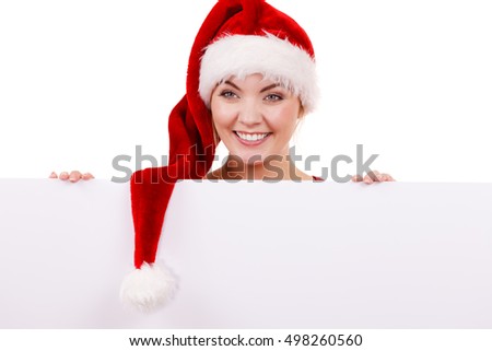 Woman holding blank empty board banner. Happy glad girl in santa claus helper hat. Christmas advertisement copyspace.