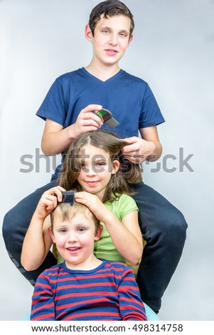 Three children who comb each others head. Efficient head lice treatment, studio portrait shot. 