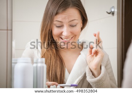 young woman holding pregnancy test