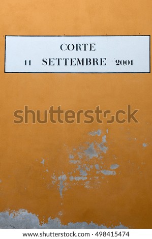 A typical sign of Venice, dedicated to the 9/11, on a yellow wall in Venice, Italy.
The sign says: "Courtyart 9 september 2011"