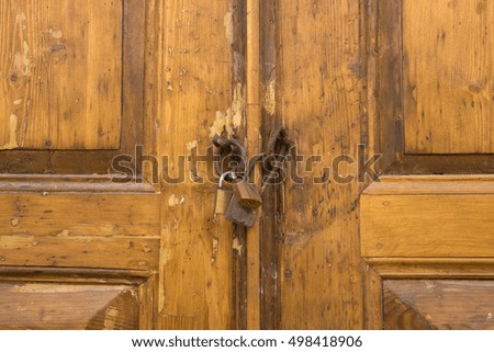 Old padlock on a wooden door.