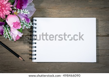 open note book with pencil on wood background