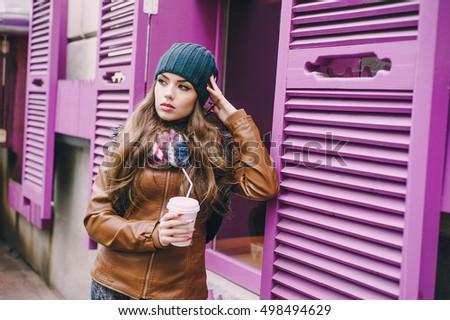 two beautiful girls walk around town fashionably and stylishly dressed with a Cup of coffee