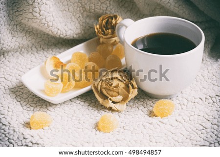 A cup of coffee, white cup and saucer white, fruit jelly on a plate