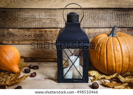 Halloween lantern and pumpkin on old wooden table