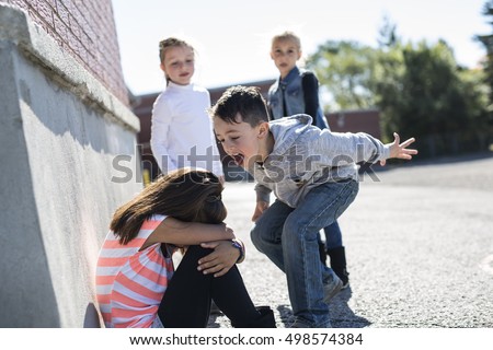 sad moment Elementary Age Bullying in Schoolyard Royalty-Free Stock Photo #498574384
