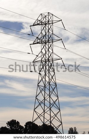 High-voltage power transmission tower on a sunset sky background