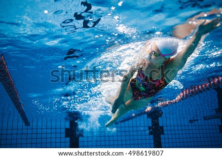 Underwater shot of fit swimmer training in the pool. Female swimmer inside swimming pool. Royalty-Free Stock Photo #498619807