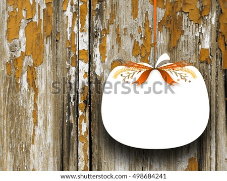 Close-up of one blank pumpkin shaped frame hanged by orange ribbon on old scratched wooden boards background