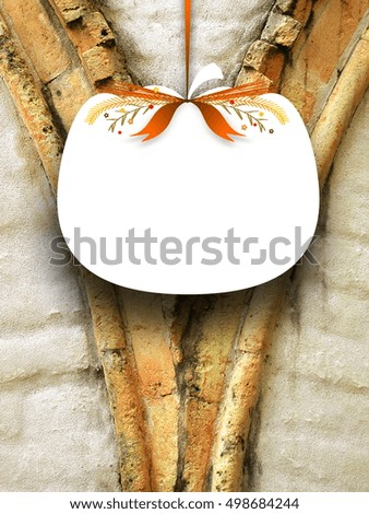 Close-up of one blank pumpkin shaped frame hanged by orange ribbon on old weathered stone arch detail