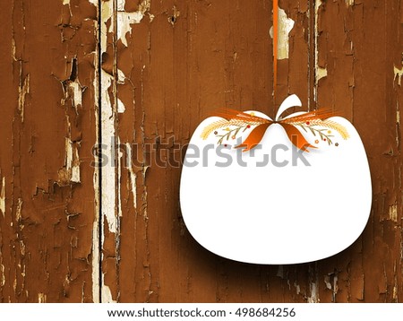 Close-up of one blank pumpkin shaped frame hanged by orange ribbon on brown wooden background