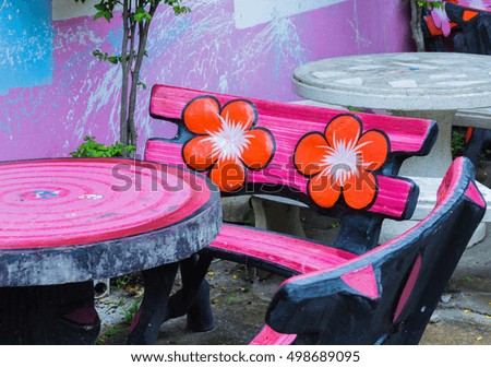 Colorful pink concrete chair with orange flower signs