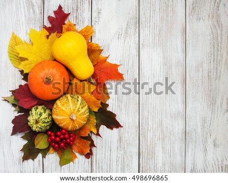 Pumpkin and autumn  leaves on a old wooden table