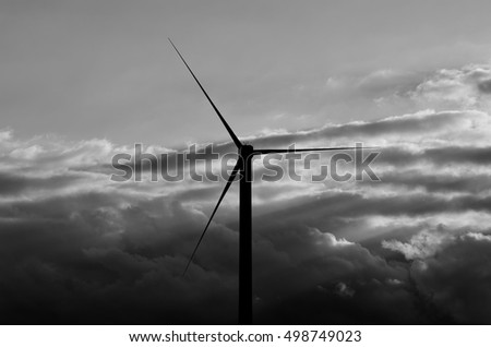 Wind turbines backlit at dawn, monochrome effect