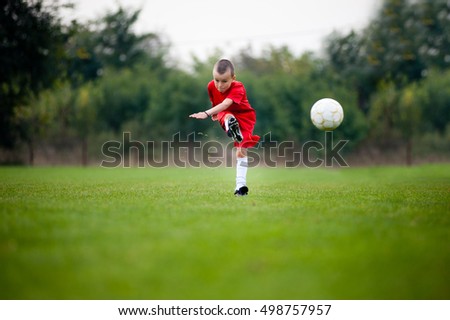 Little football player shooting the ball