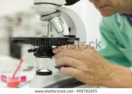 Close-up of a male scientific researcher using microscope in the laboratory. Concept: Research in laboratory