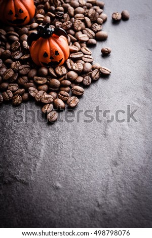 Halloween pumpkin decoration with coffee beans on dark background