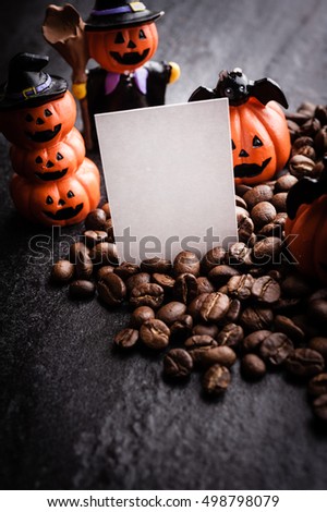 Halloween pumpkin decoration with coffee beans on dark background