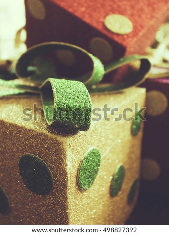 Christmas gift box decoration in gold and red colors with ribbons. Toned image.
