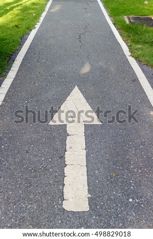 White arrow on The path in park