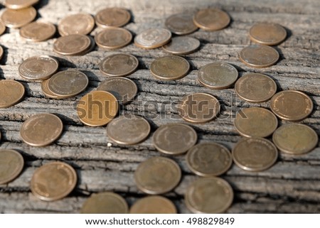 Abstract disrupted coins (Baht) on old wooden background with copy space for use