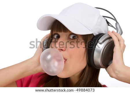 Smiling female teenager enjoy music on white background, with headphones and bubble gum