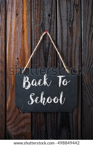 Back To School Sign Written In Chalk On Chalkboard On Rustic Vintage Wood Background. Top View Selective Focus.
