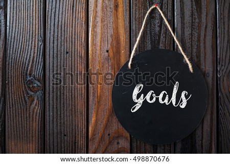 Goals Sign Written In Chalk On Chalkboard On Rustic Vintage Wood Background. Top View Selective Focus.