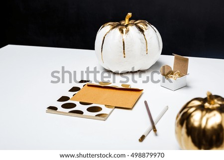 Halloween decor on white table over black background.