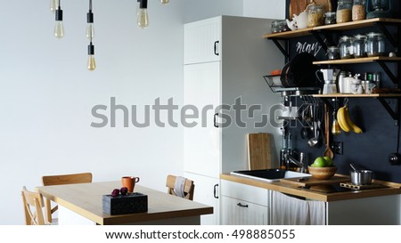 The design of the modern home kitchen in the loft-style and rustic. black wall with shelves , trays , jars , mugs , sink . Royalty-Free Stock Photo #498885055