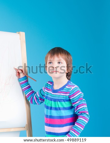 Little girl drawing with her pencil at an easel