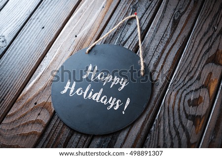 Happy Holidays Written In Chalk On Chalkboard On Rustic Vintage Wood Background. Selective Focus.
