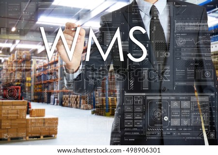 the businessman is writing things connected with the logistics in warehouse. WMS Royalty-Free Stock Photo #498906301