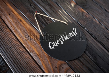Questions Sign Written In Chalk On Chalkboard On Rustic Vintage Wood Background. Selective Focus.