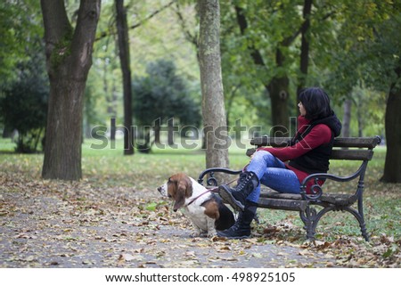  A young woman sitting in the park with a dog