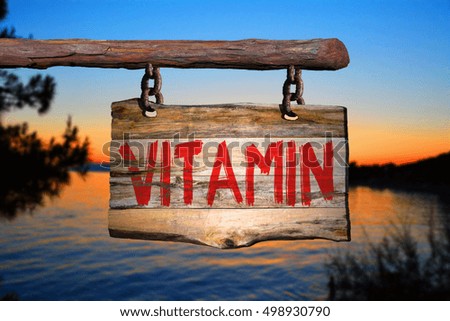 Vitamin motivational phrase sign on old wood with blurred background