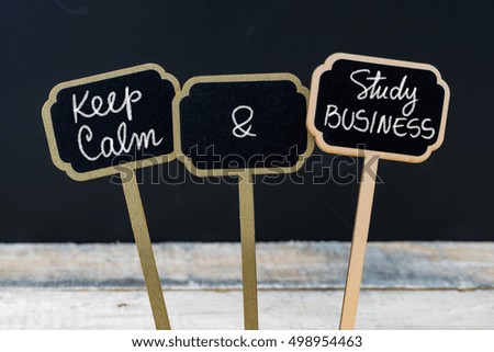 Keep Calm and Study Business message written with chalk on mini blackboard labels, defocused chalkboard and wooden table in background. Fun and humor concept