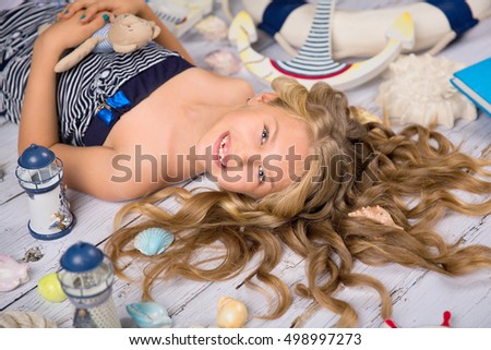 blonde girl  on the white floor with nautical decor