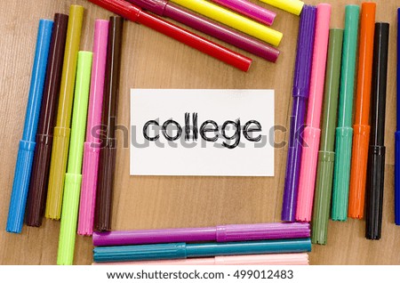 Felt-tip pen and note on a wooden background and college text concept