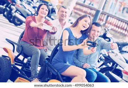 Attractive family sitting in grand tour electric and taking pictures of Europenian city