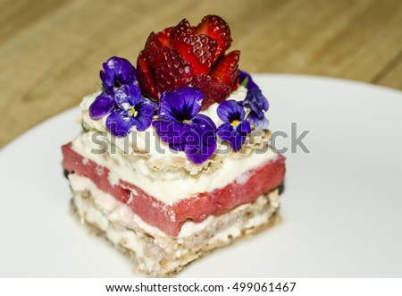 Homemade watermelon sandwich cake with mixed edible flower toppings / Cake background / Strawberry hand carved into rose bulb