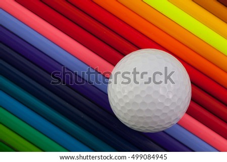 Detail of rainbow  colorful pencil and golf ball on the table