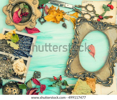 Autumn leaves and golden picture frame over bright wooden background. Scrapbook concept. Vintage style toned picture