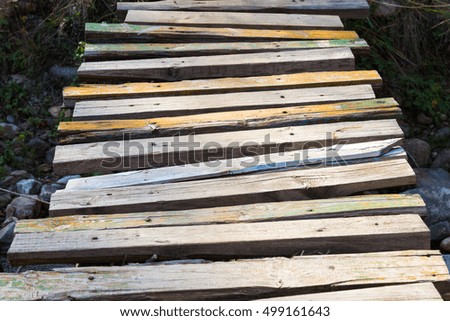 old wooden bridge of planks over the river