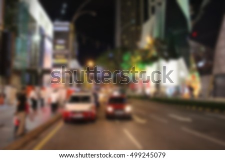 Night city view in blur. City street blurry photo. Streetlife bokeh image. Street view with pedestrians and cars defocused image. Road in big city bokeh image. Night city lifestyle blurry background